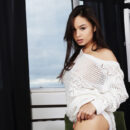 Astrid Herrara looks stunningly hot in her white off shoulder see through top and white panties. She then takes it off and starts fondling her hairless pussy on the green chair.