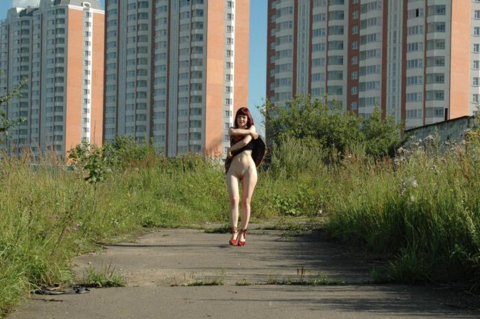 Red-haired girl Oxana D in red shoes masturbates with a dildo outdoors