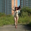 Red-haired girl Oxana D in red shoes masturbates with a dildo outdoors