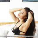 Astrid Herrara seductively unclasps her black lingerie on the bed and exposes her gorgeous knockers and smooth pinkish coochie.