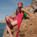 Wearing her sea gypsy costume, Firebird`s alluring beauty stands out as she bravely poses along the rocky cliff by the sea.