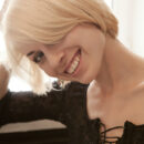 With a sweet, vivacious smile that’s as bright as the morning sunshine, Avrora debuts clad in a sexy black lace dress, posing seductively on top of the bed.