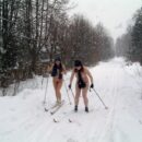 Two girls without clothes skiing in the snowfall