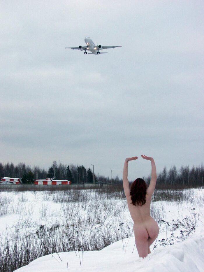 Big boobied beauty meets airplanes on a snowy field
