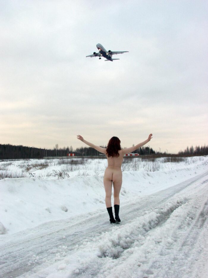 Big boobied beauty meets airplanes on a snowy field