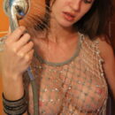 Holly Haim removes her fishnet-like dress in the shower and lets the water drip down her slim figure, juicy melons and puffy hairless pussy.