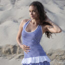 Kolumbina A bends over in the sand on the beach