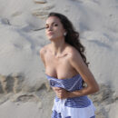 Kolumbina A bends over in the sand on the beach