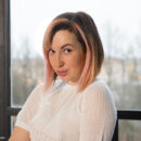 Leka B enticingly divests her clothes by the window and exposes her voluptuous figure and hairy cunt.