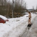 Long-haired young naked girl Alena B near the snow car