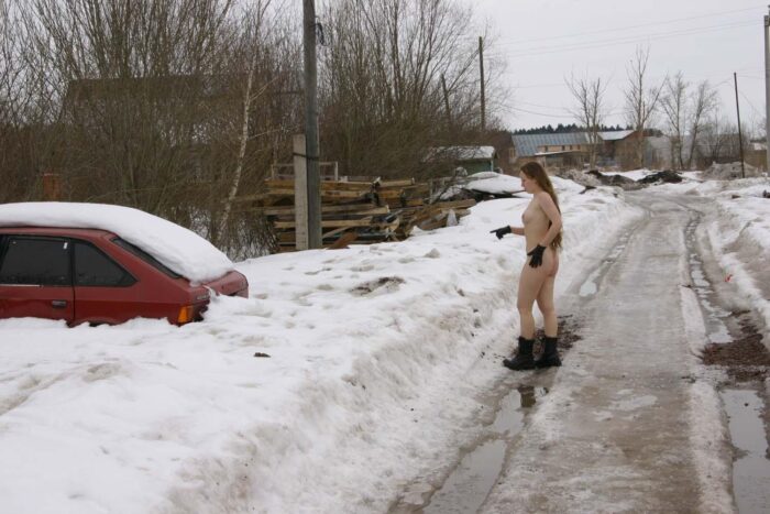 Long-haired young naked girl Alena B near the snow car