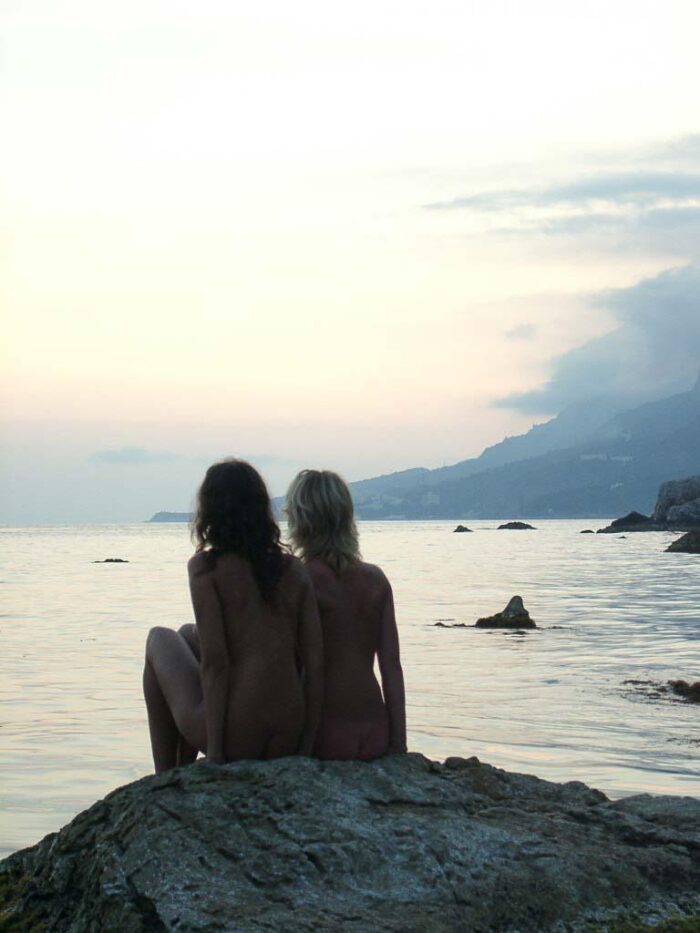 Two young naked russian girls jump from stone in the sea