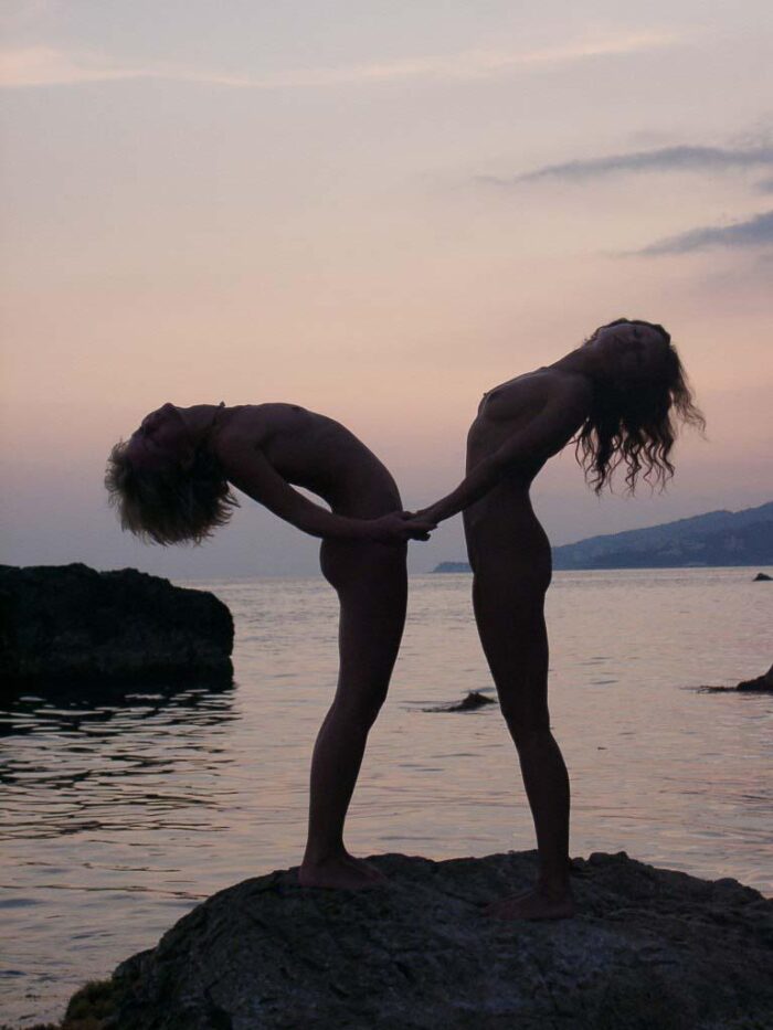 Two young naked russian girls jump from stone in the sea