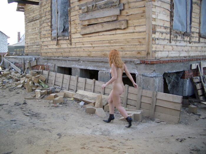 Girl Lilia in black boots on construction site