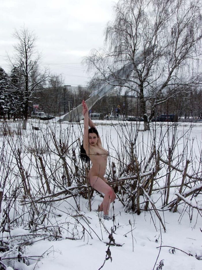 Young brunette Masha R walks naked in the snow in the city