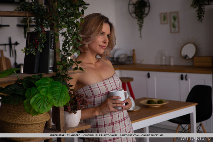 Amber Pearl drinks coffee in kitchen. She divest her clothes and exposes her slim physique and manicured cunt.