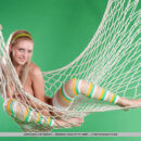 Fun and sweet Lapochka looks absolutely stunning in her bright striped stockings and yellow headband, posing playfully in a fishnet hammock.