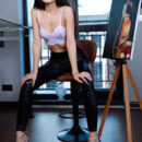 Azumi Liu looks chic in her leather pants and high heels. She slips out of her clothes and uncover her slim sexy body and smooth cunt all the while she is painting by the window.