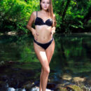 Rosalina takes off her black lingerie in the middle of a river in the forest and flashes her huge bottom and shaved moist cunt.