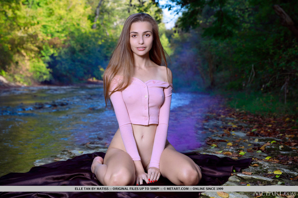 Elle Tan is deep in the forest when she takes off her pink crop top cardigan and uncovers her slim figure and shaved punani by the river.