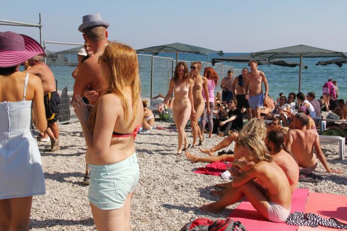 Lots of people look at two shameless young naked girls