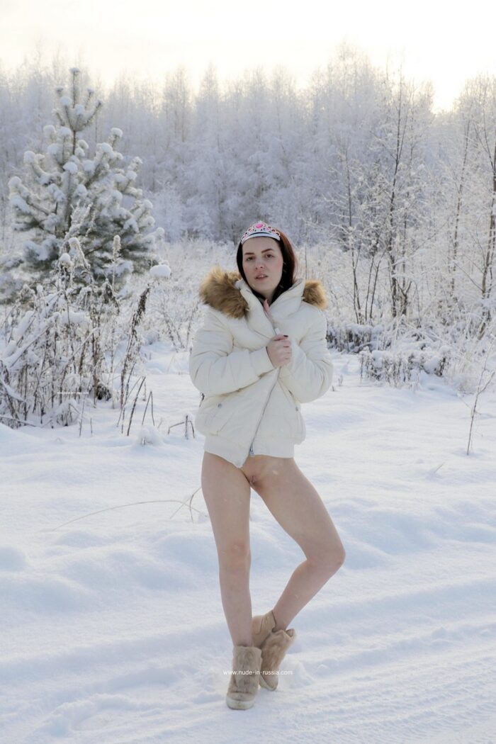 Brunette Alena M undresses on a snowy road in the village
