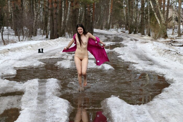 Russian girl Katja P walking barefoot in snowy puddles