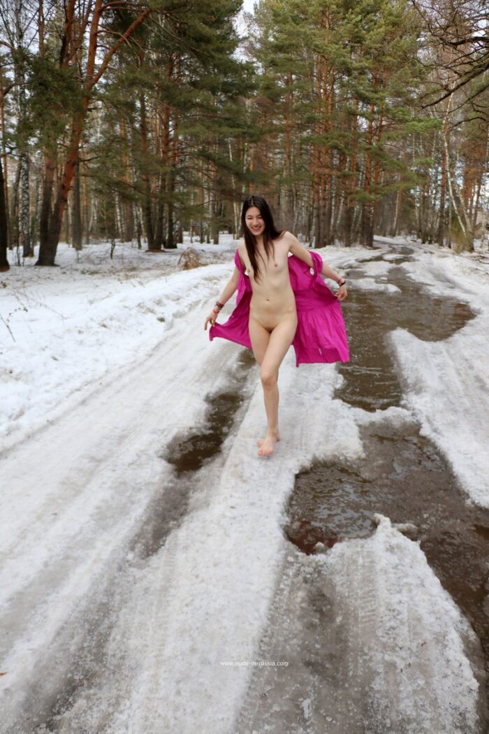 Russian girl Katja P walking barefoot in snowy puddles