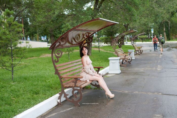 Short-haired brunette Nastja shows her body in a city park