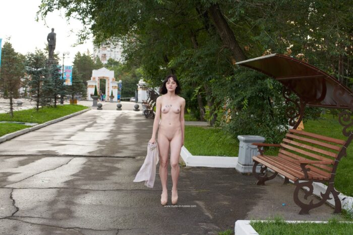 Short-haired brunette Nastja shows her body in a city park