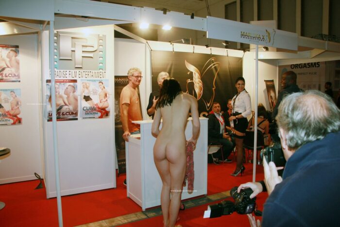 Slender brunette Nastia B undresses at an erotic exhibition