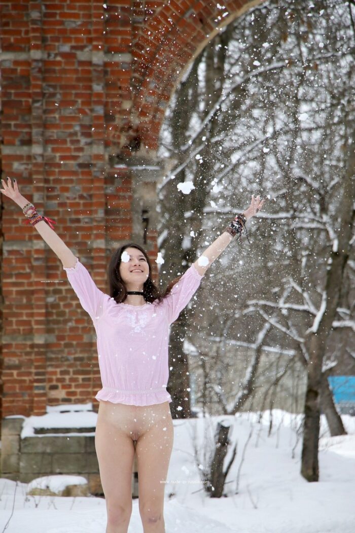 Smiling brunette Katja P walks barefoot in the snow