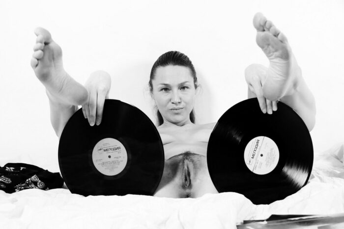 Smiling girl Irena K with beautiful ass and cunt posing with records