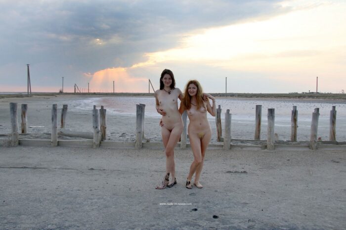 Two girls posing naked in the mud