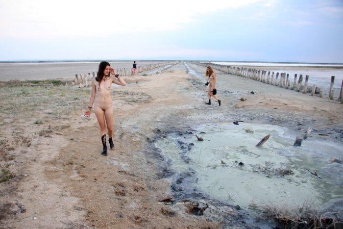 Two girls posing naked in the mud