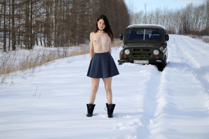 Naked brunette Katja P in boots on a snowy road