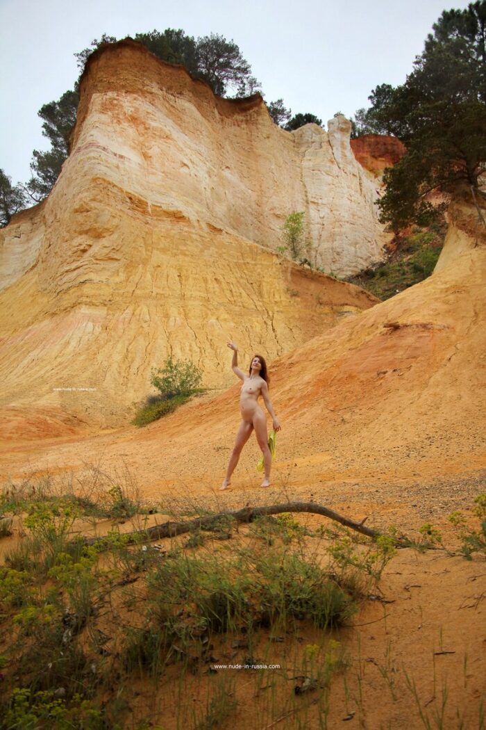 Smiling russian teen shows her goods at red mountains
