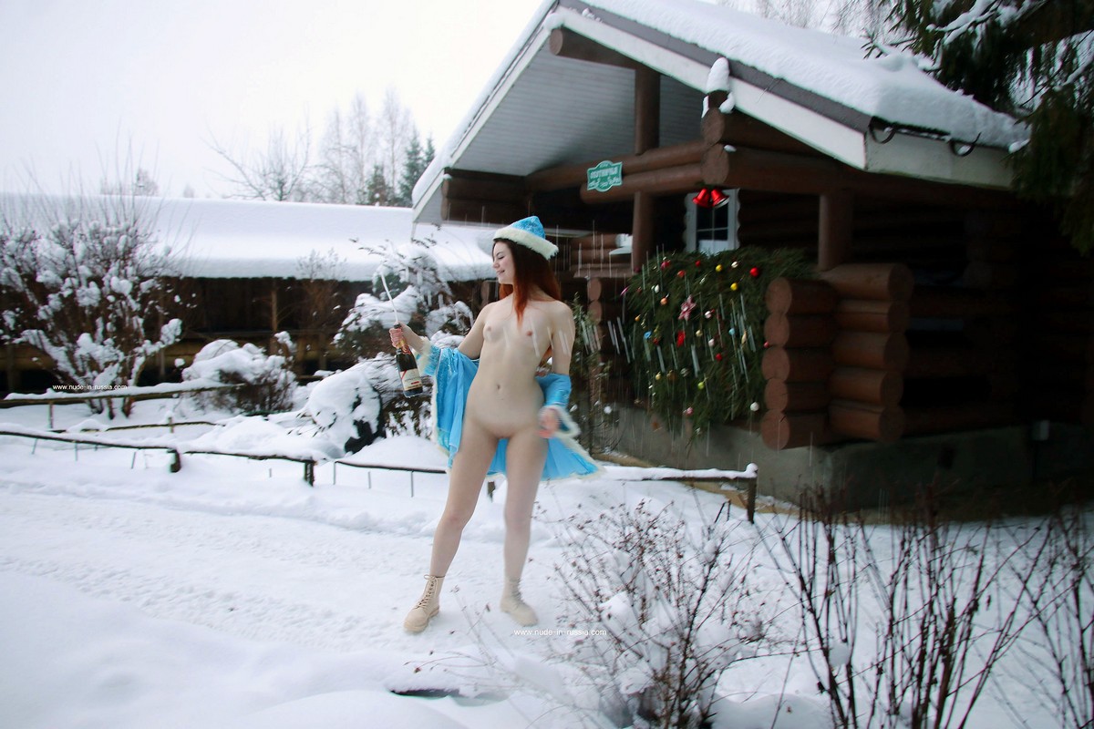 Red-haired Snow Maiden drinks champagne near a country house