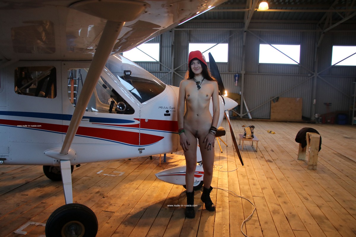 Young Russian brunette Katja P undresses at a small airfield