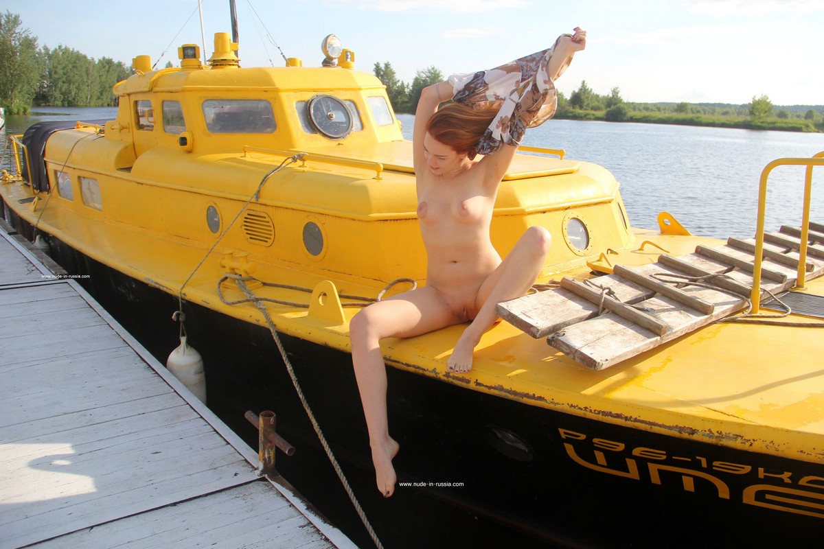 Russian girl Lera S with red hair posing on a yellow boat