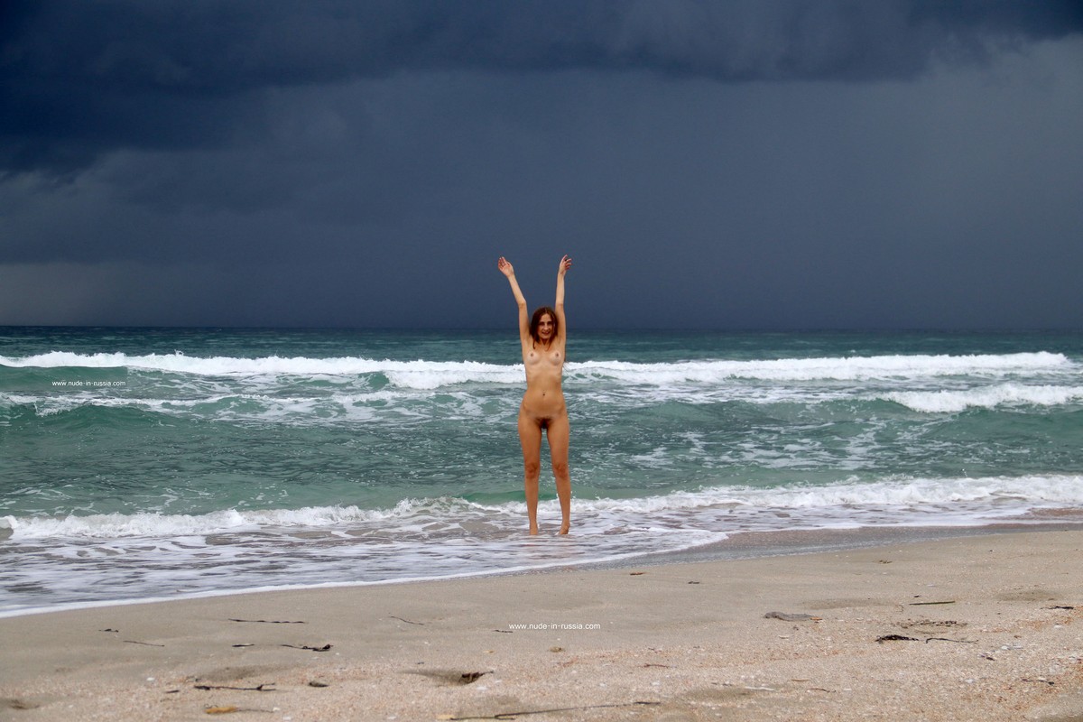 Smiling young girl Valentina K bathes in the sea before a thunderstorm