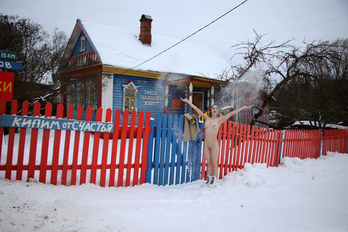 A young Russian girl Natali plays with snow near the house-museum