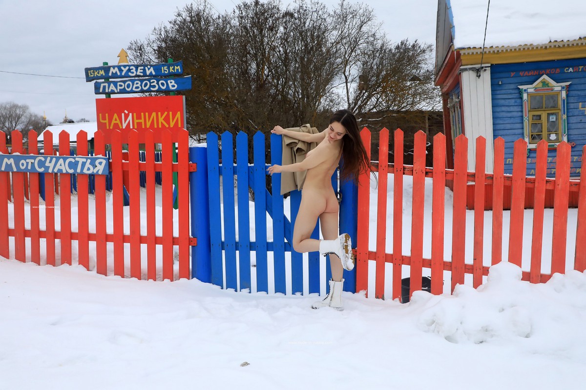 A young Russian girl Natali plays with snow near the house-museum
