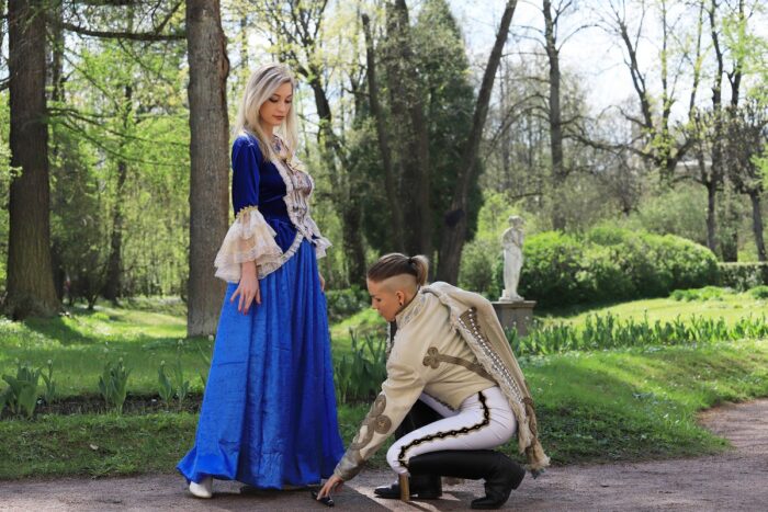 Two girls in old costumes perform a theatrical performance in the park