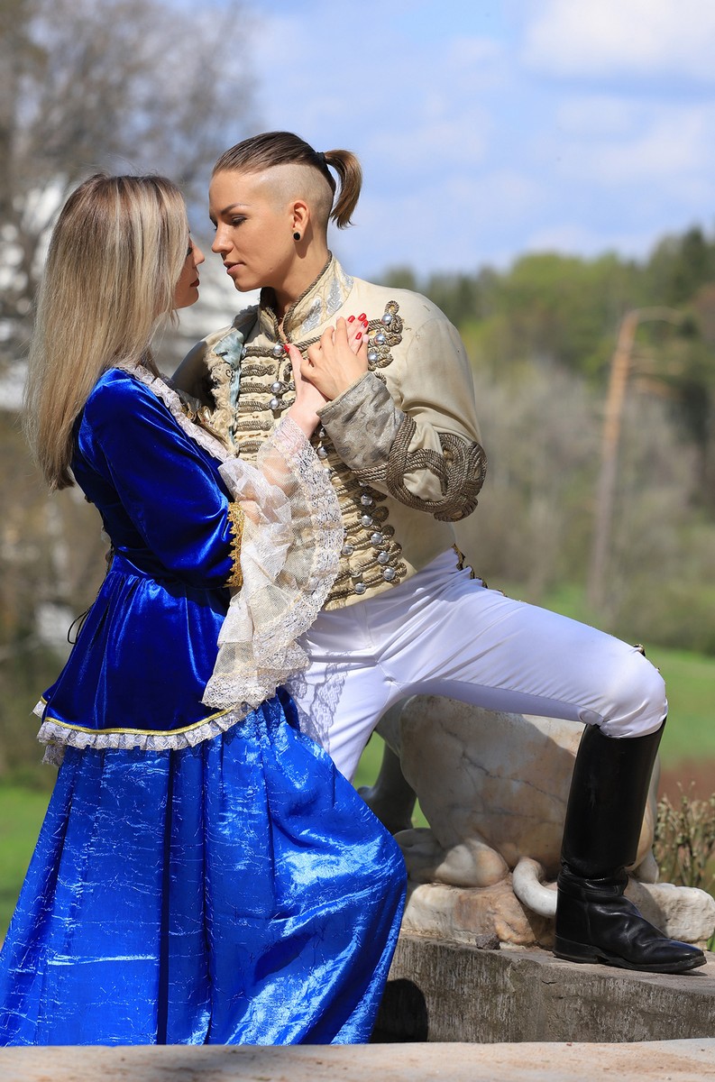 Two girls in old costumes perform a theatrical performance in the park