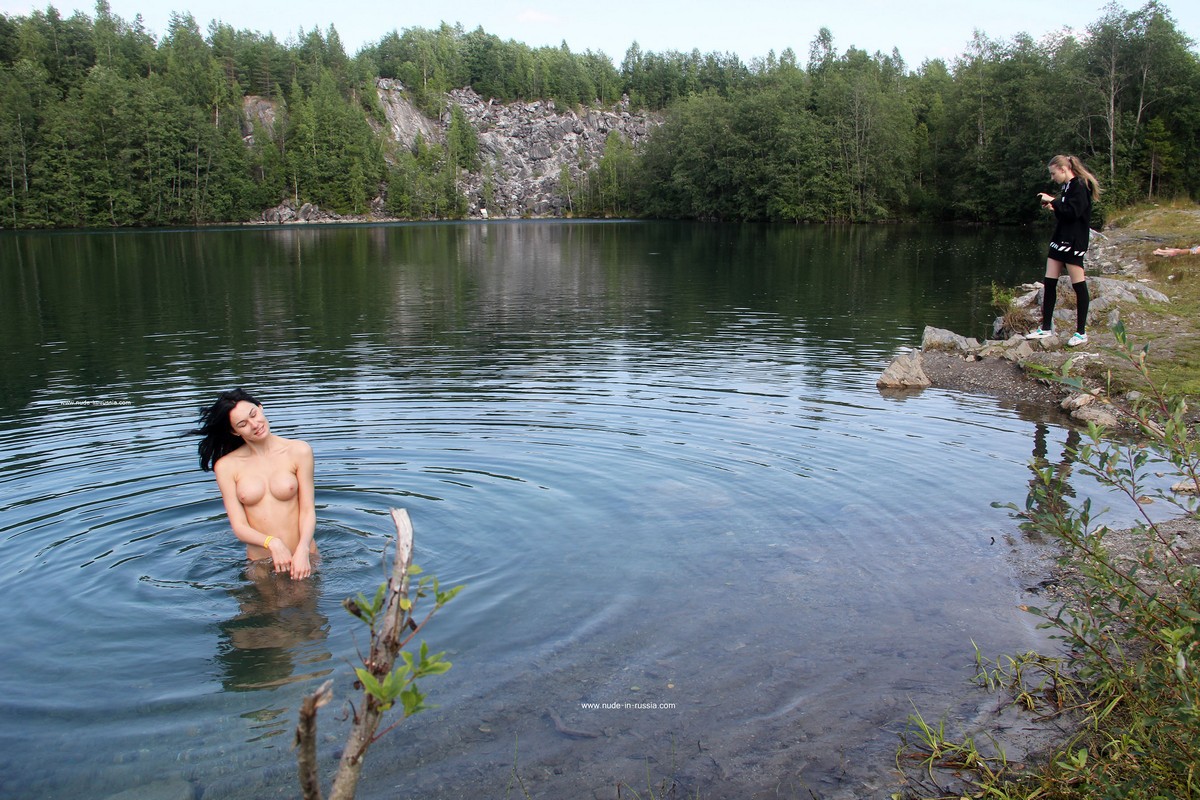 Two girls undress and go swimming in the lake next to strangers