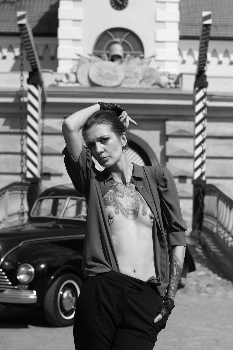 Tattooed and pierced skinny girl Lia A in an old car