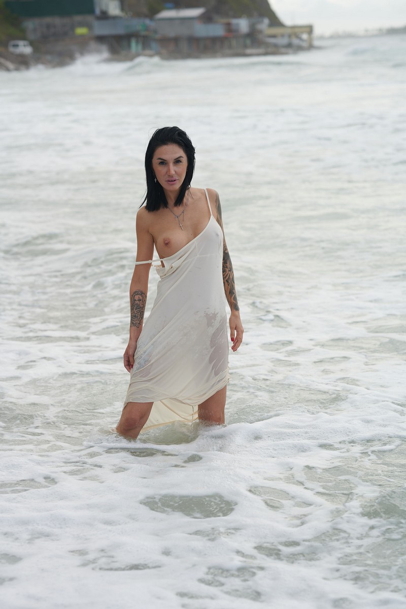Beautiful tattooed brunette Julia splashes in the Eastern Sea