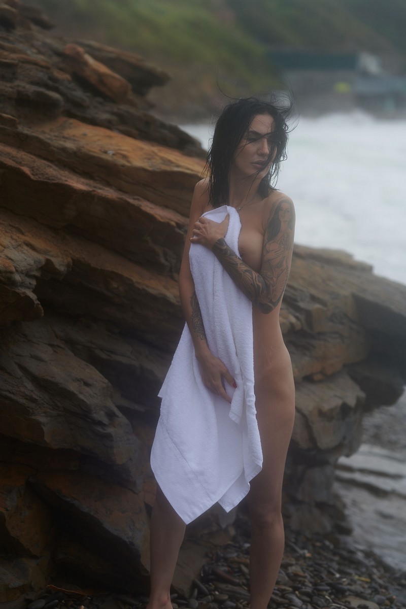 Beautiful tattooed brunette Julia splashes in the Eastern Sea