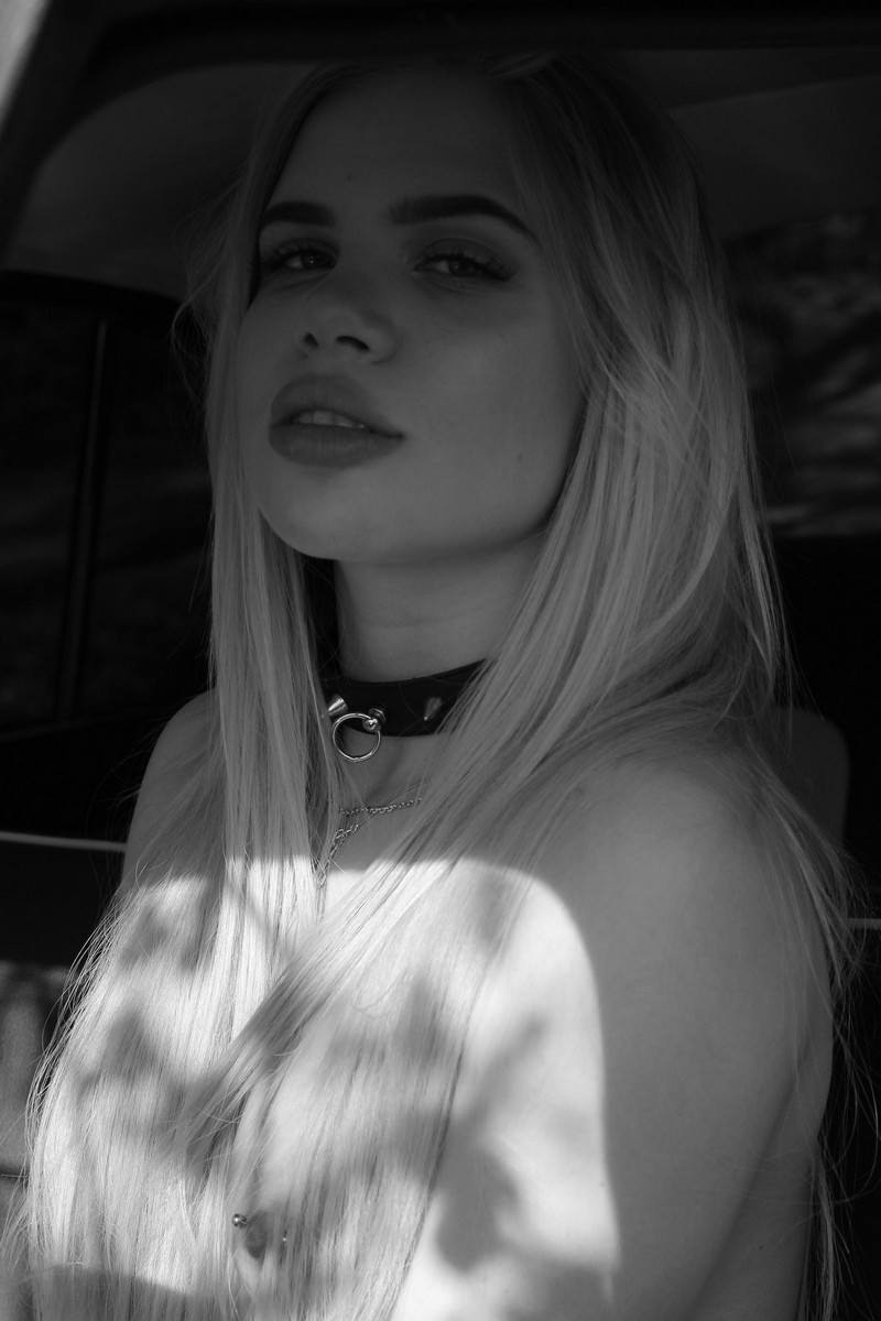 Long-haired blonde Maria near an old taxi